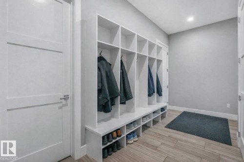 Built-in storage solutions with individual cubbies and integrated shoe shelving - 8927 120 Street Nw, Edmonton, AB - Indoor Photo Showing Other Room