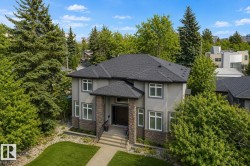 Gray stucco exterior with dark shingle roofing - 
