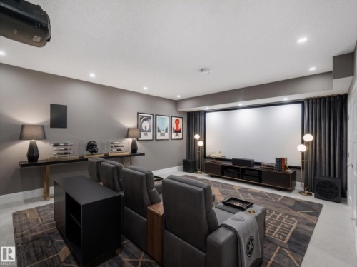Dedicated media room featuring a large projection screen, recessed ceiling lighting, and dark wall-to-wall drapery - 8927 120 Street Nw, Edmonton, AB - Indoor