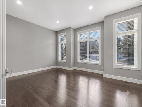Spacious room featuring wood-finish flooring, multiple windows with blinds, recessed lighting, and a neutral wall color - 8927 120 Street Nw, Edmonton, AB - Indoor Photo Showing Other Room