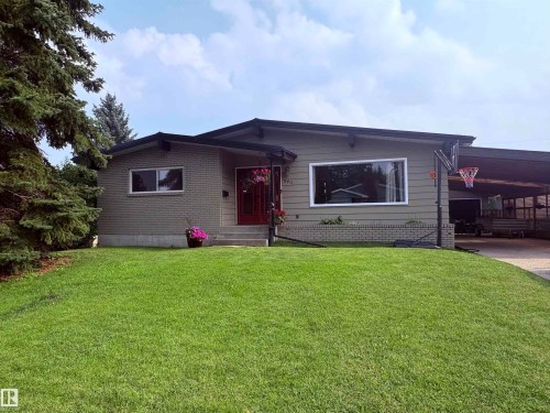 Mid-century modern residence featuring a brick and siding exterior, expansive front window, covered carport, and a well-maintained front lawn - 5411 44 Ave, Wetaskiwin, AB - Outdoor