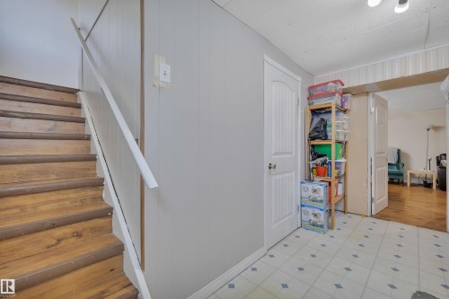 Wood-finish staircase with white handrail - 5411 44 Ave, Wetaskiwin, AB - Indoor Photo Showing Other Room