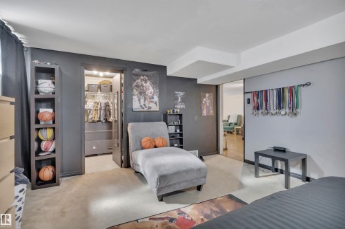 Carpeted room with dark accent wall and built-in closet system - 5411 44 Ave, Wetaskiwin, AB - Indoor