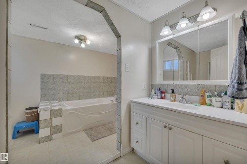 Double vanity with white cabinetry and integrated sink - 5411 44 Ave, Wetaskiwin, AB - Indoor Photo Showing Bathroom