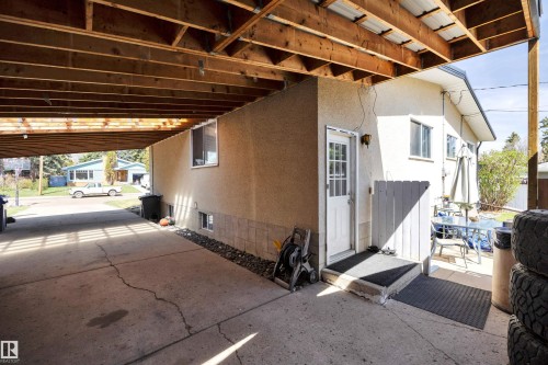 Covered concrete driveway with exposed wood beam ceiling - 5411 44 Ave, Wetaskiwin, AB - Indoor