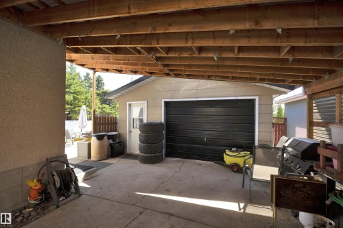 Covered concrete patio with exposed wood joist ceiling - 5411 44 Ave, Wetaskiwin, AB - 