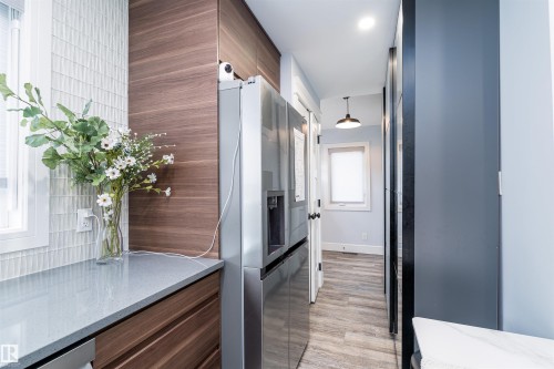 Kitchen with light-toned countertop, wood-finish cabinetry, and a textured tile backsplash - 10934 80 Avenue Nw, Edmonton, AB - Indoor Photo Showing Other Room