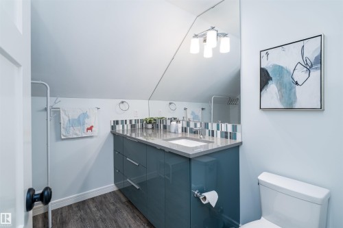 Modern vanity featuring a sleek countertop, integrated rectangular sink, and chrome-finish faucet - 10934 80 Avenue Nw, Edmonton, AB - Indoor Photo Showing Bathroom