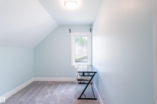 Attic room featuring a single window, sloped ceilings, light blue walls, gray carpet, and a ceiling-mounted light fixture - 10934 80 Avenue Nw, Edmonton, AB - Indoor Photo Showing Other Room