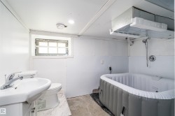 Bathroom featuring a pedestal sink, toilet, and an inflatable spa tub - 