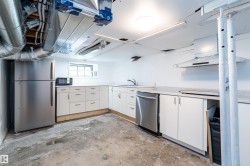 Compact kitchen area featuring white cabinetry, a stainless steel refrigerator, and a built-in dishwasher - 