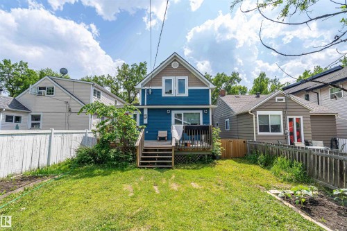 Expansive backyard featuring a manicured lawn, a wooden deck, and a privacy fence - 10934 80 Avenue Nw, Edmonton, AB - Outdoor