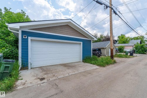 Detached two-car garage featuring blue horizontal siding and brown shake-style siding on the gable - 10934 80 Avenue Nw, Edmonton, AB - Outdoor