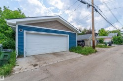 Detached two-car garage featuring blue horizontal siding and brown shake-style siding on the gable - 