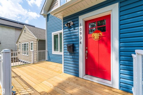 Vibrant red entry door with transom-style window and bright white trim - 10934 80 Avenue Nw, Edmonton, AB - Outdoor With Deck Patio Veranda
