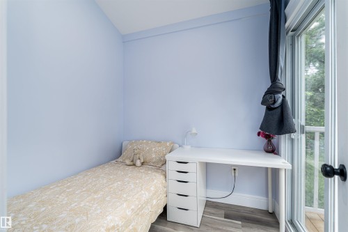 Room with light blue walls and wood-finish flooring - 10934 80 Avenue Nw, Edmonton, AB - Indoor Photo Showing Bedroom