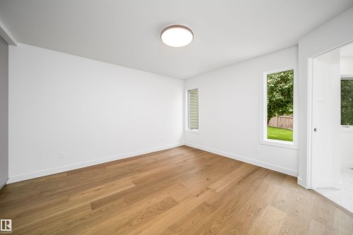 Wood-finish flooring, white walls, two vertical windows, and a flush-mount ceiling light - #A 12 Invermere Pl, St. Albert, AB - Indoor Photo Showing Other Room