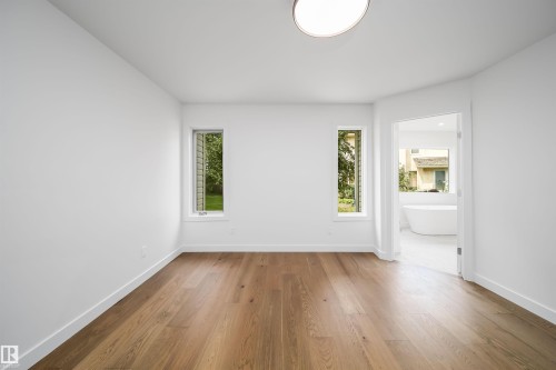 Wood-finish flooring, recessed lighting, and dual vertical windows - #A 12 Invermere Pl, St. Albert, AB - Indoor Photo Showing Other Room