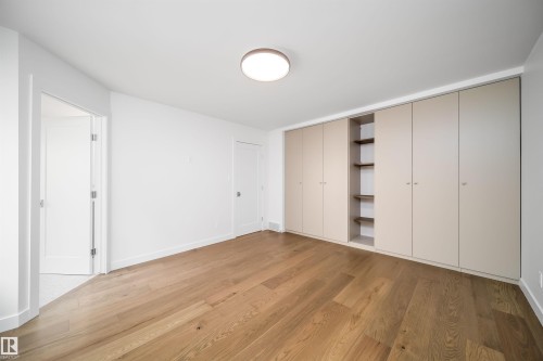 Wood-finish flooring, built-in cabinetry with shelving, recessed lighting, and white walls - #A 12 Invermere Pl, St. Albert, AB - Indoor Photo Showing Other Room