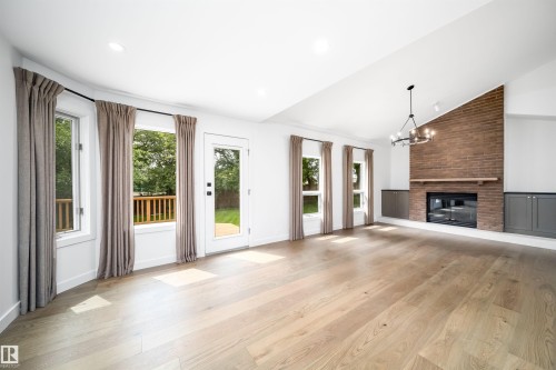 Vaulted ceiling, wood-finish flooring, brick-clad fireplace with mantel, recessed lighting, and built-in cabinetry - #A 12 Invermere Pl, St. Albert, AB - Indoor Photo Showing Living Room With Fireplace