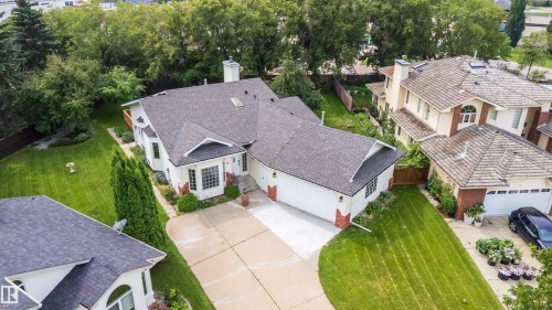 White exterior with dark shingle roof and brick accents - #A 12 Invermere Pl, St. Albert, AB - Outdoor