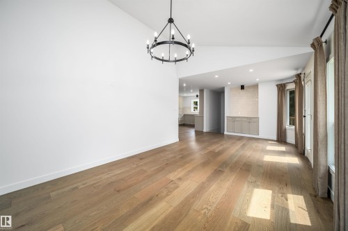 Vaulted ceilings, wood-finish flooring, recessed lighting, and a built-in cabinetry unit - #A 12 Invermere Pl, St. Albert, AB - Indoor Photo Showing Other Room