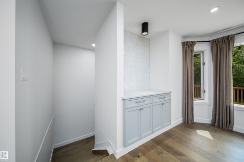 Built-in cabinetry with a light countertop, subway tile backsplash, and light wood-finish flooring - #A 12 Invermere Pl, St. Albert, AB - Indoor Photo Showing Other Room