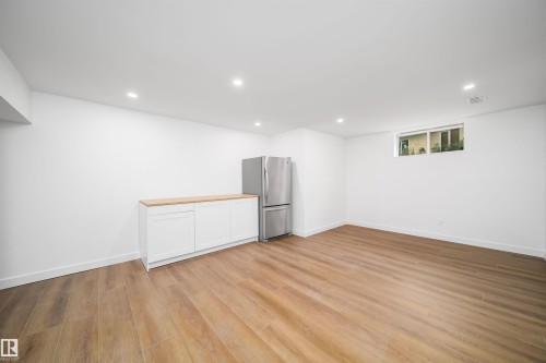 Recessed ceiling lighting, wood-finish flooring, built-in white cabinetry, light wood-finish countertop, and a window - #A 12 Invermere Pl, St. Albert, AB - Indoor Photo Showing Other Room