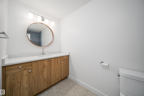 Floating wood-finish vanity with a white countertop and undermount sink - #A 12 Invermere Pl, St. Albert, AB - Indoor Photo Showing Bathroom