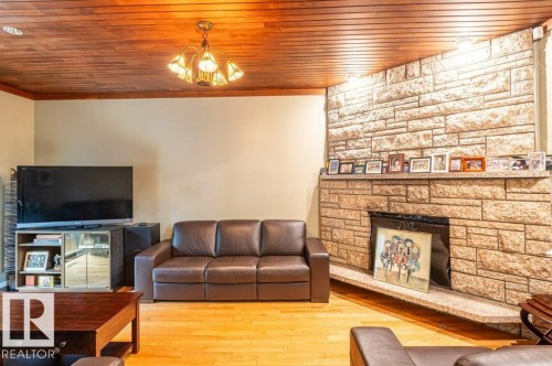 Living space featuring a natural wood plank ceiling and hardwood flooring - 14514 101 Avenue Nw, Edmonton, AB - Indoor Photo Showing Living Room With Fireplace