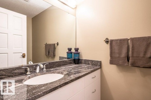 Vanity featuring a dark patterned granite countertop, an oval undermount sink, and chrome fixtures - 14514 101 Avenue Nw, Edmonton, AB - Indoor Photo Showing Bathroom