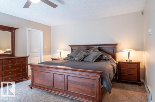 Carpeted room with a ceiling fan, light neutral wall color, and a white interior door - 14514 101 Avenue Nw, Edmonton, AB - Indoor Photo Showing Bedroom