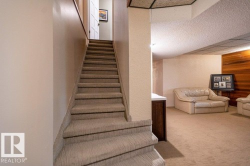 Carpeted staircase with a partial railing leading to an upper level - 14514 101 Avenue Nw, Edmonton, AB - Indoor Photo Showing Other Room