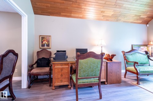 Sloped wood-paneled ceiling above a room with wood-finish flooring and light-toned walls - 14514 101 Avenue Nw, Edmonton, AB - Indoor