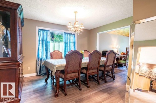 Dining area featuring wood-finish flooring and a wide window with natural light - 14514 101 Avenue Nw, Edmonton, AB - Indoor Photo Showing Dining Room