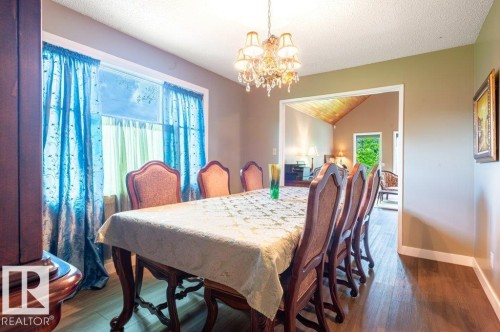 Formal dining area featuring wood-finish flooring and a wide entryway to another room with a vaulted wood-paneled ceiling - 14514 101 Avenue Nw, Edmonton, AB - Indoor Photo Showing Dining Room