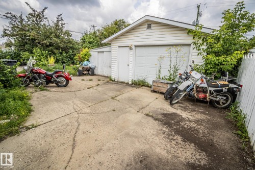 Detached garage featuring white siding, a single garage door, and a concrete driveway - 4322 49 Ave, St. Paul Town, AB - Outdoor