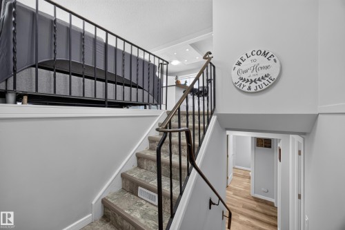 Staircase with wrought iron railing, light gray walls, and wood-finish flooring - 156 Clareview Road Nw, Edmonton, AB - Indoor Photo Showing Other Room