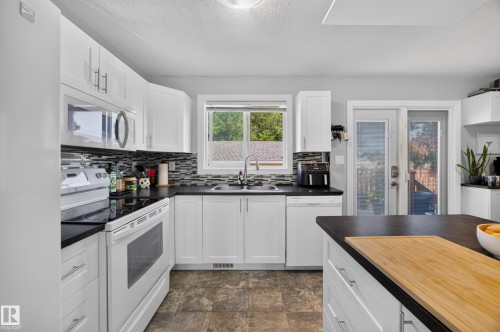 Modern kitchen featuring white cabinetry with stainless steel appliances, including a double wall oven and microwave - 156 Clareview Road Nw, Edmonton, AB - Indoor Photo Showing Kitchen With Double Sink