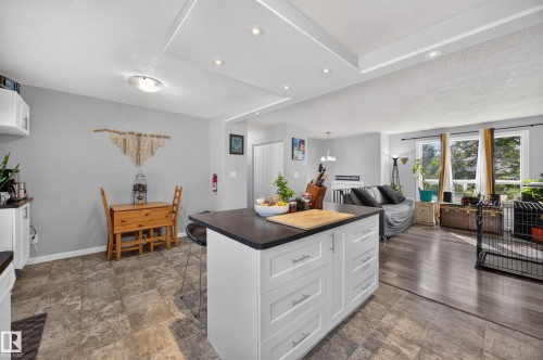 Kitchen island with built-in storage, contrasting dark countertop, recessed lighting, and wood-finish flooring - 156 Clareview Road Nw, Edmonton, AB - Indoor