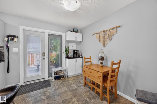 Sliding glass door, built-in white cabinetry, black countertops, and tile flooring - 156 Clareview Road Nw, Edmonton, AB - Indoor