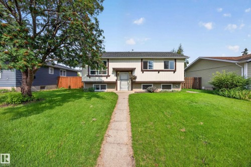 Welcoming split-level home featuring a manicured front lawn, mature shade trees, and a concrete walkway leading to the entry - 156 Clareview Road Nw, Edmonton, AB - Outdoor