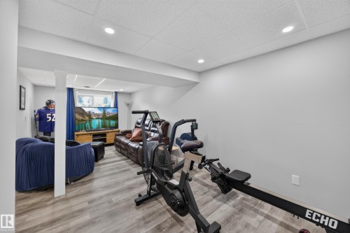 Dedicated fitness room featuring wood-finish flooring, recessed ceiling lighting, and equipped with stationary cycling equipment - 156 Clareview Road Nw, Edmonton, AB - Indoor Photo Showing Gym Room