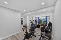 Recessed lighting, wood-finish flooring, light gray wall paint, white trim, and a drop ceiling - 
