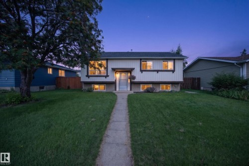 Split-level residence featuring a prominent front lawn, concrete pathway, and multiple windows across two levels - 156 Clareview Road Nw, Edmonton, AB - Outdoor