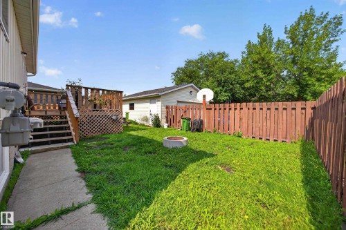 Expansive backyard featuring a wood deck with stairs, concrete patio, privacy fence, and a detached garage - 156 Clareview Road Nw, Edmonton, AB - Outdoor With Deck Patio Veranda
