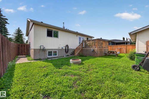 Expansive backyard with a wooden fence, concrete patio, and elevated wood deck - 156 Clareview Road Nw, Edmonton, AB - Outdoor With Exterior