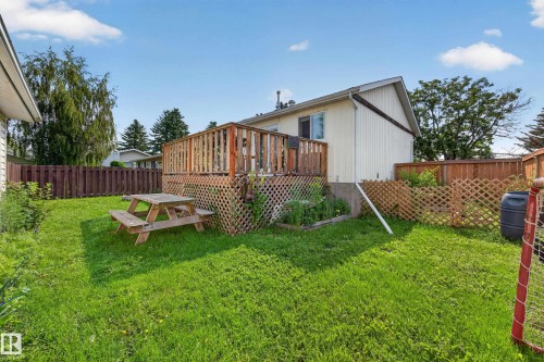 Expansive green space featuring a wooden deck with lattice skirting and privacy fencing - 156 Clareview Road Nw, Edmonton, AB - Outdoor