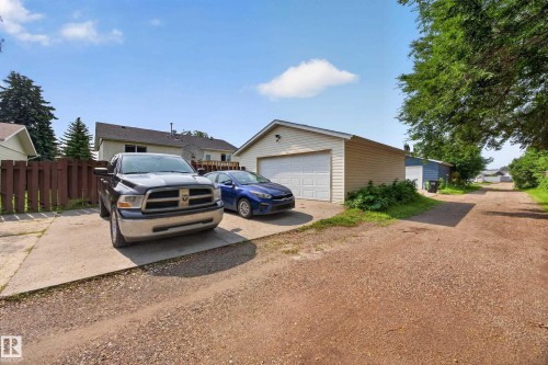 Detached garage with horizontal siding, concrete driveway, and an additional gravel parking area - 156 Clareview Road Nw, Edmonton, AB - Outdoor With Exterior