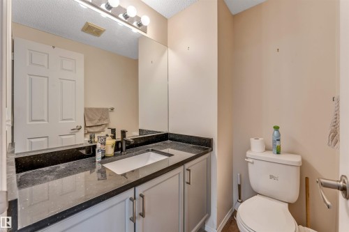 Vanity with dark speckled countertop, undermount sink, and matte black faucet - 3032 31 Avenue Nw, Edmonton, AB - Indoor Photo Showing Bathroom